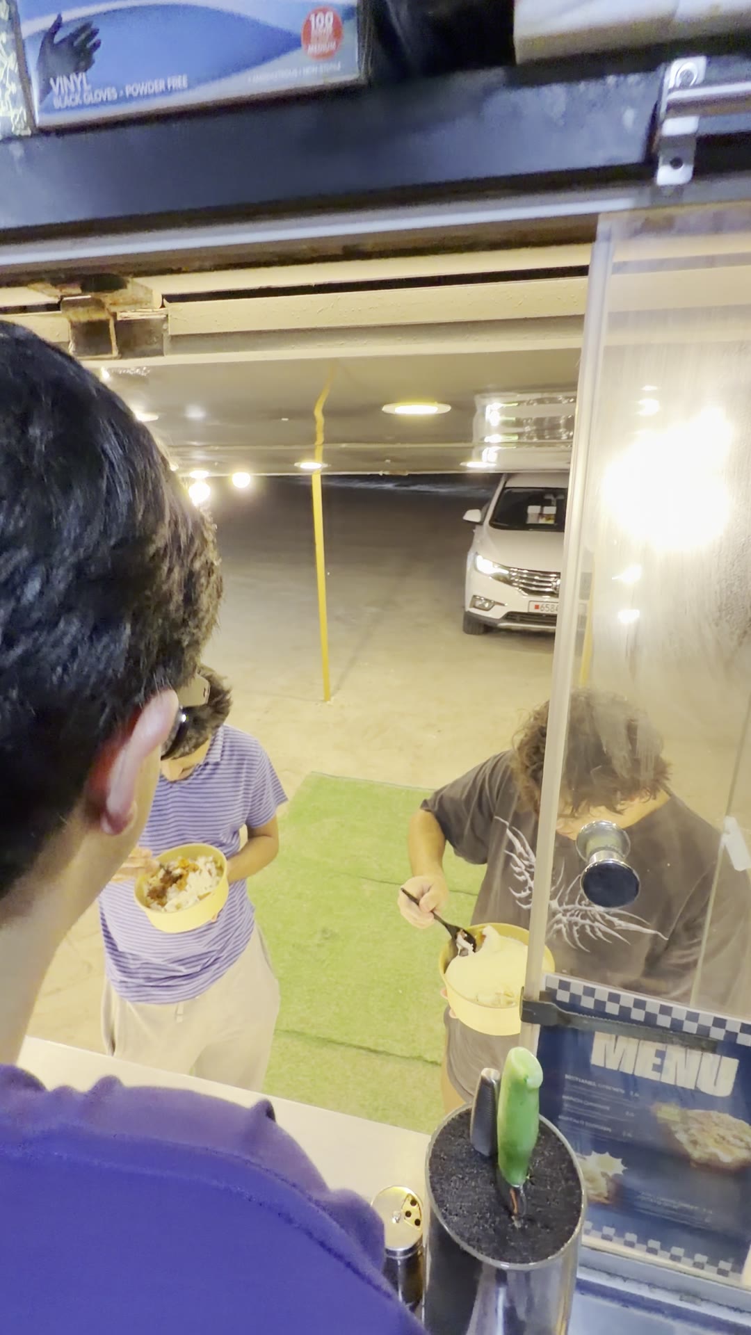 Customers enjoying loaded potato bowls at the Spudlicious truck at night