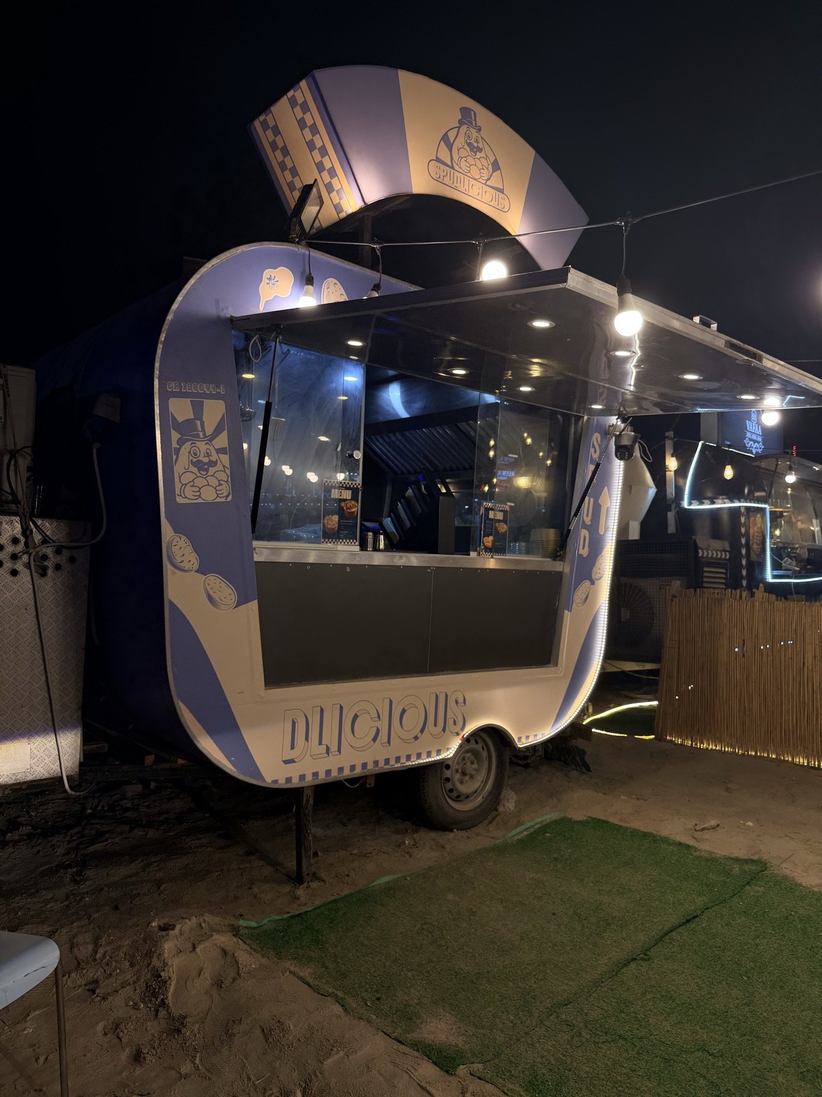 The fully set-up Spudlicious food truck glowing at night, ready to serve an event